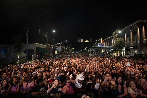 Lots of people in the downtown streets of Starkville, MS at a big party.